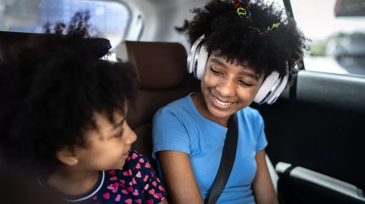 Sisters in backseat of car on a road trip