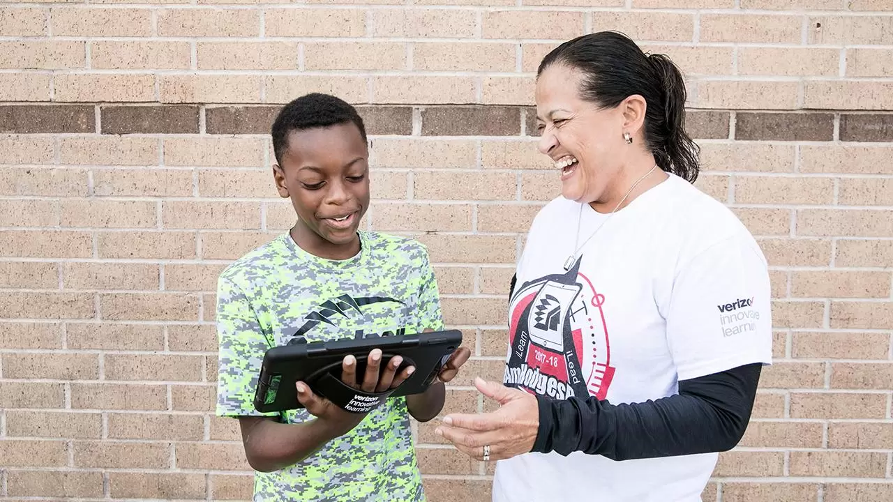 Mrs. West gives Tyler a lesson on his iPad