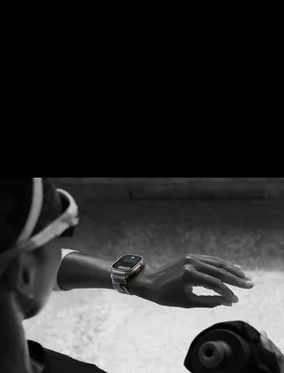 Corredor mirando el Apple Watch Ultra 2 en la muñeca izquierda, haciendo el gesto de doble toque con los dedos índice y pulgar de la mano izquierda