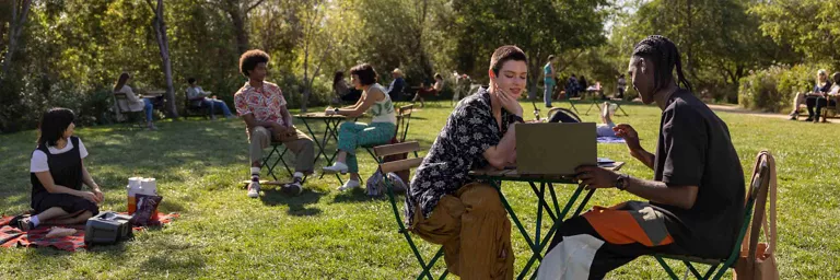 amigos usando una laptop en un parque