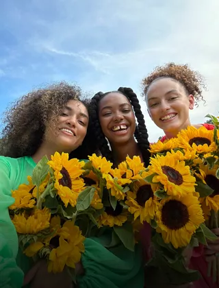 Una selfie bien nítida e intensa de tres personas con flores.