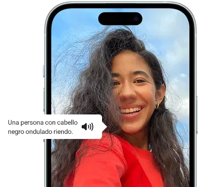 Un iPhone 15 mostrando la función VoiceOver que anuncia la información sobre la imagen: "Una persona con cabello ondulado y negro riéndose"