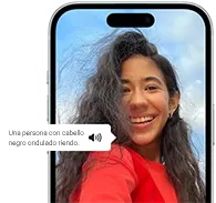 iPhone 15 mostrando un anuncio de voz en off que describe una fotografía como: una persona con el pelo negro ondulado riendo